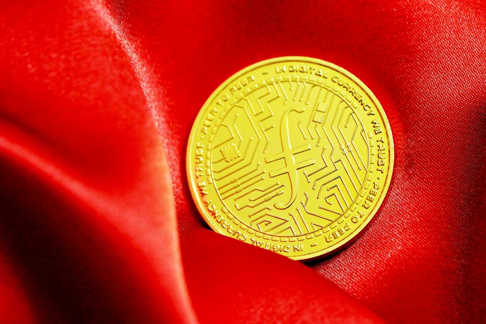 a close up of a gold coin on a red cloth