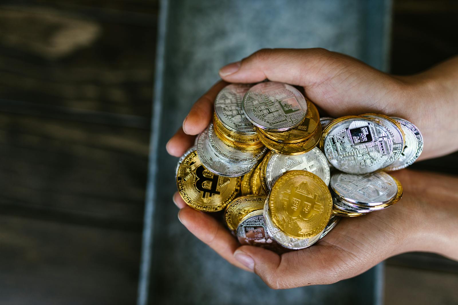 A close-up of hands holding various cryptocurrency coins, representing digital finance.