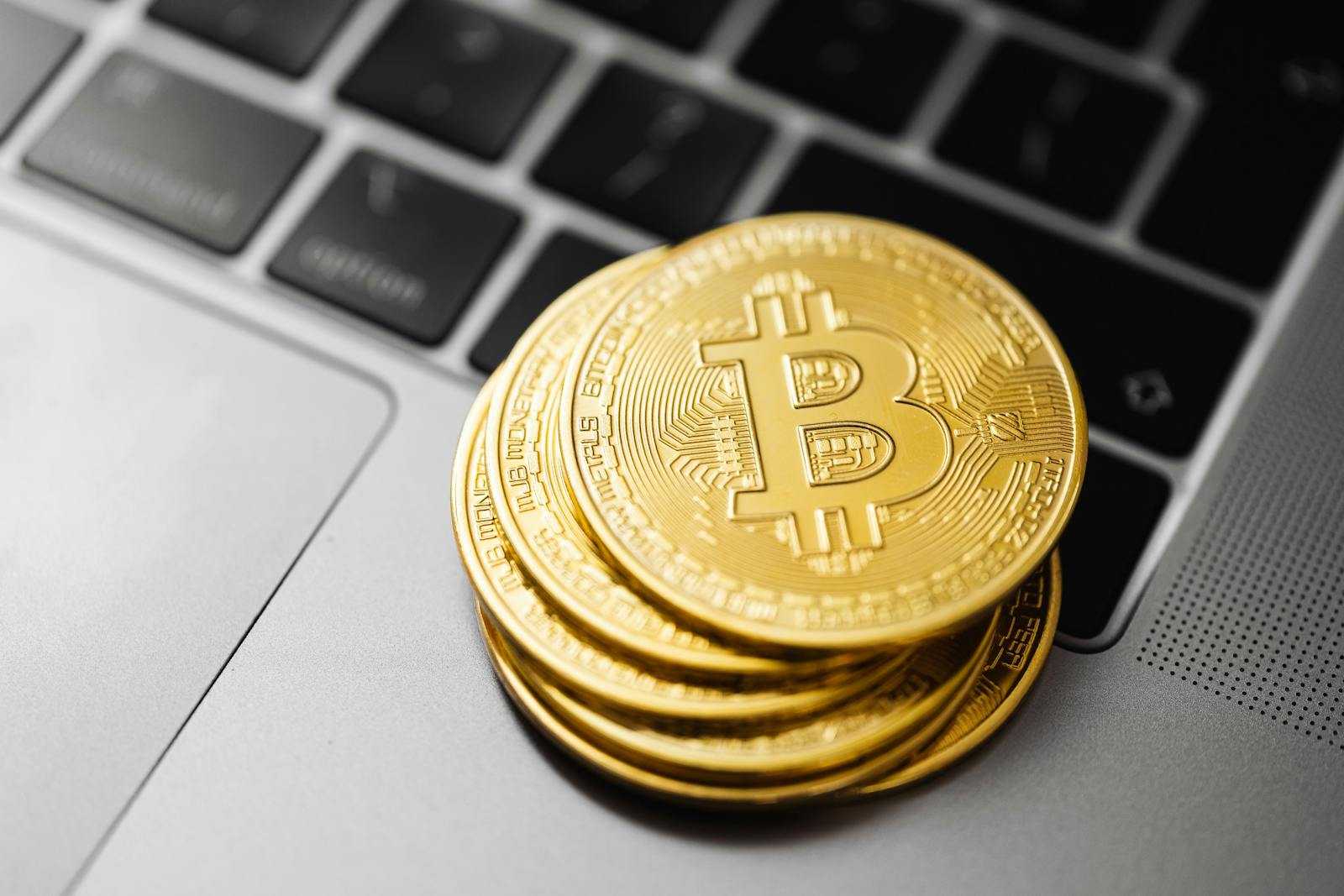 Gold bitcoins stacked on a laptop keyboard symbolizing digital currency and blockchain technology.