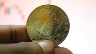 a person holding a bit coin in their hand