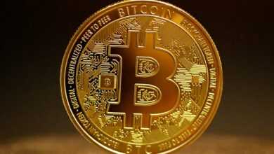 a golden bitcoin sitting on top of a table