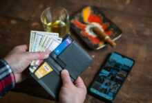 person holding black leather bifold wallet