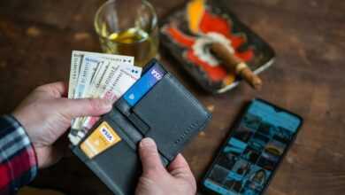 person holding black leather bifold wallet
